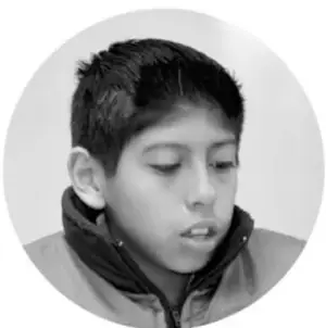 Fotografía de un niño leyendo o recitando.