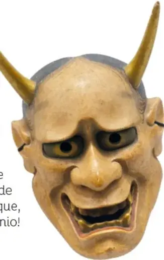 Máscara japonesa hannya de madera clara, con dos cuernos largos dorados, ceño fruncido, ojos dorados, boca abierta con dientes y mirada de angustia.