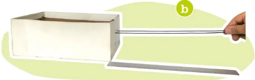 Manos amarrando y pasando el cordón por los orificios de la caja.