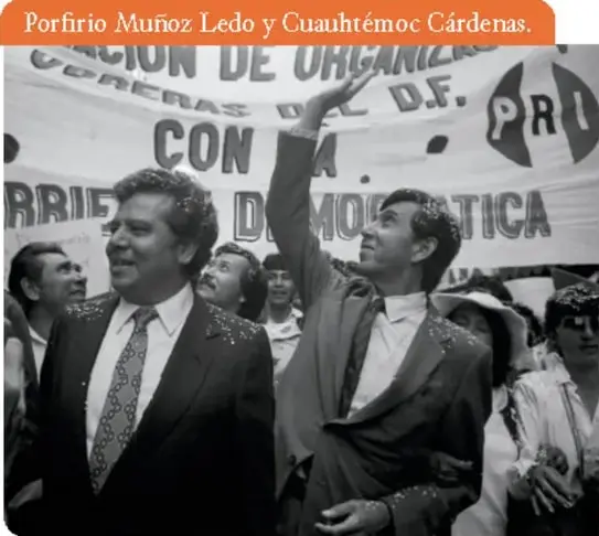Fotografía en blanco y negro de una manifestación política. Se observan dos hombres en primer plano: uno con traje y corbata, y otro levantando el brazo. Detrás hay una manta con las siglas PRI y las palabras 'CON... DE... D.F.'