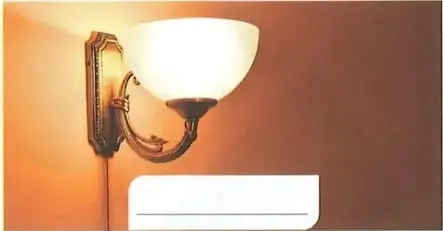 Lámpara encendida en una pared; representa el uso de la electricidad.