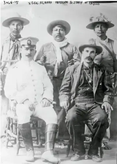 Fotografía histórica en blanco y negro de un grupo de hombres armados, algunos con sombrero y uniforme, identificados como 'Gral. Alvaro Obregón & Staff of Yaquis'.