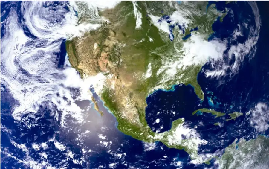 Fotografía satelital de la Tierra mostrando América del Norte, con nubes y el océano.