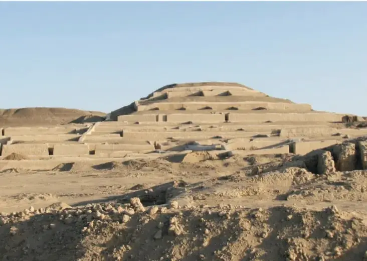 Fotografía de la Gran Pirámide de Cahuachi en Perú, de adobe, con niveles escalonados y lugares de excavación arqueológica al pie.