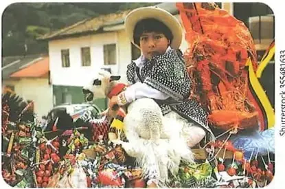 Niño participa en una expresión tradicional y festiva identificada como Pase del Niño en Cuenca.