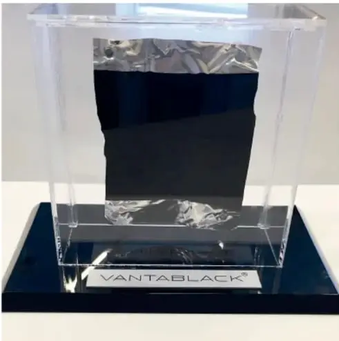 Fotografía de un cubo de vidrio con una muestra de Vantablack, el material más negro del mundo, sobre una base negra con la palabra VANTABLACK.