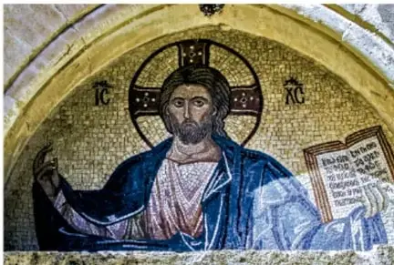 Mosaico bizantino de Cristo Pantocrátor con nimbo dorado, sosteniendo un libro abierto, sobre fondo dorado.