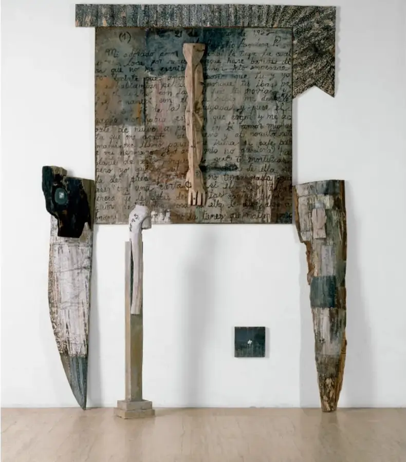 Instalación escultórica titulada Formas violadas (1994) de Alejandro Aguilera: un panel rectangular de madera con escritura manuscrita y una figura antropomorfa tallada, acompañado de tres piezas verticales de madera desgastada y una pequeña placa oscura al centro.