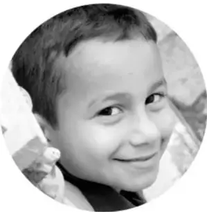 Fotografía circular en blanco y negro de un niño sonriente que se apoya en la mano.