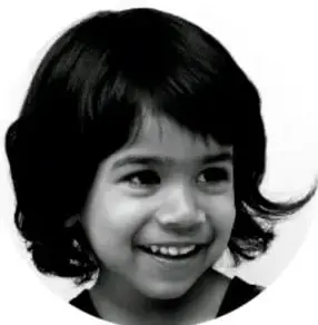 Fotografía en blanco y negro del rostro sonriente de una niña pequeña, con cabello oscuro y corto.