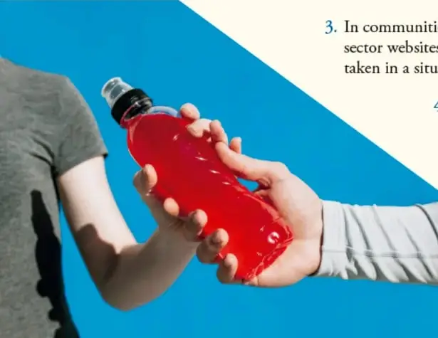 Persona sosteniendo una botella de agua roja.