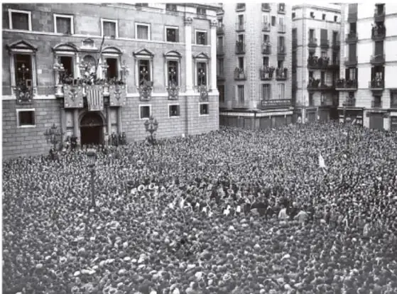 Fotografía en blanco y negro de una multitud concentrada frente a un edificio de gobierno con balcones, durante un acto público de la Segunda República Española.
