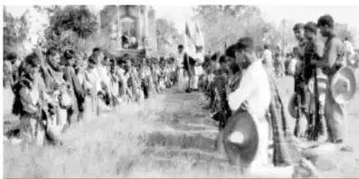 Fotografía en blanco y negro de un grupo de personas, aparentemente cristeros, en un camino rural.
