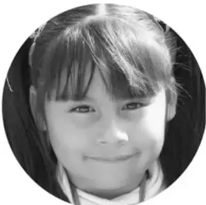 Fotografía de una niña sonriente con cabello recogido.