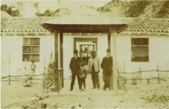 Fotografía histórica de una hacienda rural de la Sierra del Ecuador, con una construcción y varias personas frente a ella.
