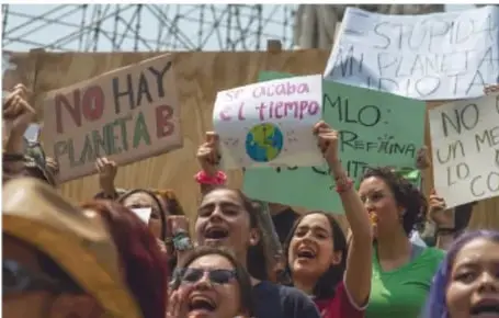 Jóvenes en una protesta climática con carteles como 'No hay planeta B' y 'Stop al cambio climático'.