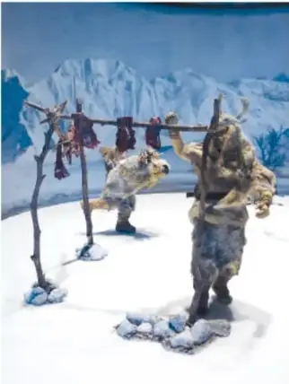 Escultura de piedra de una deidad sentada con un gran tocado, exhibida en una vitrina.
