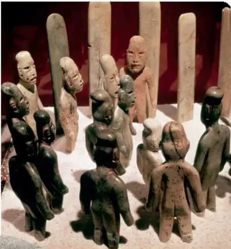 Figuras de jade, serpentina y granito de la cultura olmeca, dispuestas en fila.