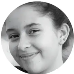 Retrato en blanco y negro de una estudiante sonriente.