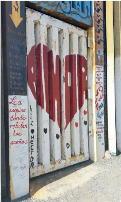 Portón metálico pintado con un corazón rojo y la palabra "Rimor"; en un costado se lee "La esquina donde rebotan los buenos" y nombres dedicados (Lili, Héctor).