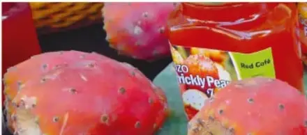 Fotografía de un mercado: tunas rosadas frescas junto a frascos de productos de tuna (etiqueta en inglés 'Prickly Pear').