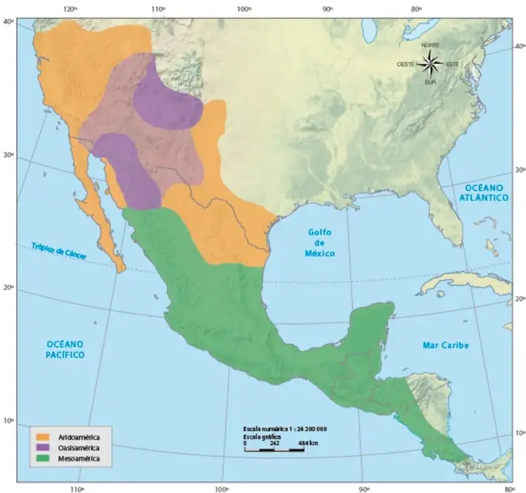 Mapa de América del Norte y Central con tres áreas coloreadas: Aridoamérica (naranja) en el norte y noroeste de México y suroeste de Estados Unidos, Oasisamérica (morado) en el suroeste de Estados Unidos y norte de México, y Mesoamérica (verde) en el centro y sur de México hasta Centroamérica. Incluye rosa de los vientos, Trópico de Cáncer, océano Pacífico, océano Atlántico, golfo de México, mar Caribe, escala numérica 1:24 200 000, escala gráfica de 0 a 484 km y leyenda de los tres colores.