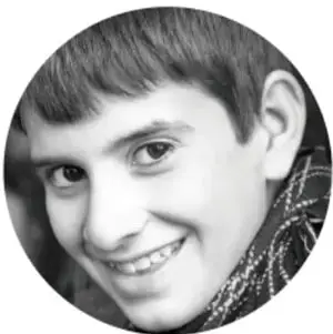 Fotografía en blanco y negro de un niño sonriente, representativa de la población infantil beneficiada por los planes educativos.