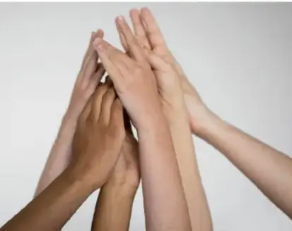 Fotografía de varias manos de distintos tonos de piel unidas y superpuestas, símbolo de la diversidad y la igualdad entre los seres humanos.