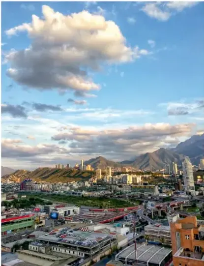 Vista panorámica de una ciudad con montañas al fondo y edificios.
