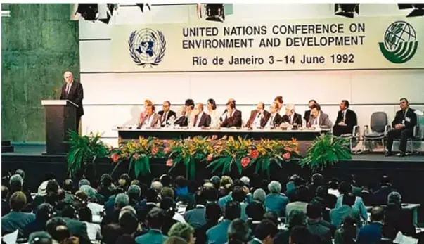 Fotografía documental de la United Nations Conference on Environment and Development, Rio de Janeiro, 3–14 June 1992, con un orador en el podio y los delegados sentados en el panel.