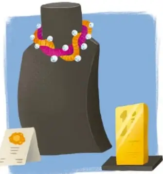 Ilustración de un salero o soporte negro con un collar de cuentas de colores (naranja, blanco, rosa), acompañado de un pañuelo amarillo y una tarjeta o etiqueta con una flor, sobre fondo azul.