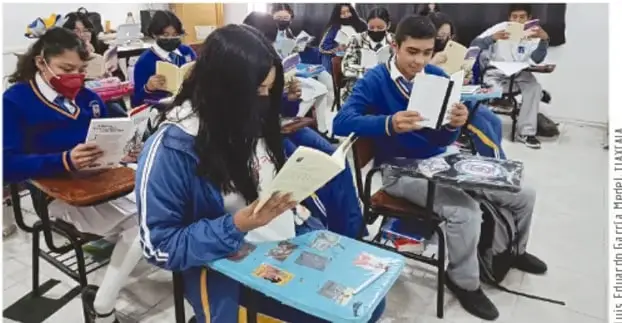 Fotografía de estudiantes de Telesecundaria con uniforme azul, sentados en el aula leyendo libros; crédito a Luis Eduardo García Méndez, TOMALA.
