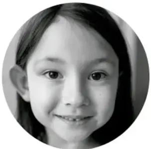 Fotografía en blanco y negro del rostro sonriente de una niña, usada como ícono de la sección.