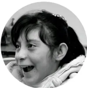 Fotografía de una niña sonriendo, con chamarra de invierno.