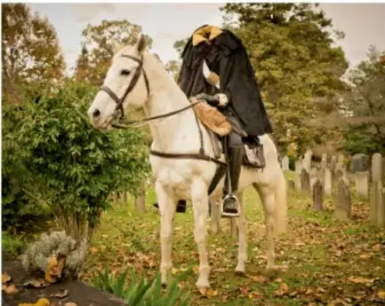 Fotografía de un jinete sin cabeza con capa oscura montado en un caballo blanco dentro de un panteón, con tumbas y árboles alrededor.
