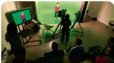 Cámara de televisión en un set con fondo verde y equipo de grabación (televisión).