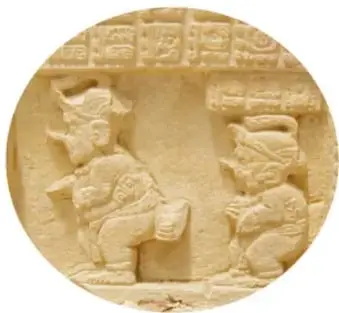 Fotografía de un relieve de piedra prehispánico con dos figuras humanas talladas que parecen caminar o danzar con tocados.