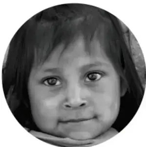 Fotografía circular en blanco y negro del rostro de una niña pequeña de ojos grandes, cabello oscuro y expresión seria.
