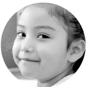 Fotografía en blanco y negro de la rostro de una niña sonriente.