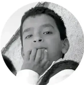 Fotografía de un niño pensativo con la mano en la boca.