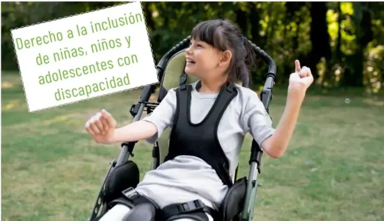 Fotografía de una niña en silla de ruedas sonriendo y levantando la mano, con un cartel que dice: 'Derecho a la inclusión de niñas, niños y adolescentes con discapacidad'.