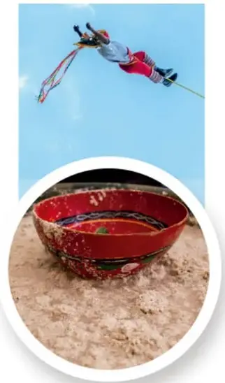 Fotografía de un volador de Papantla en pleno descenso invertido, con cinta de colores, durante la ceremonia ritual.