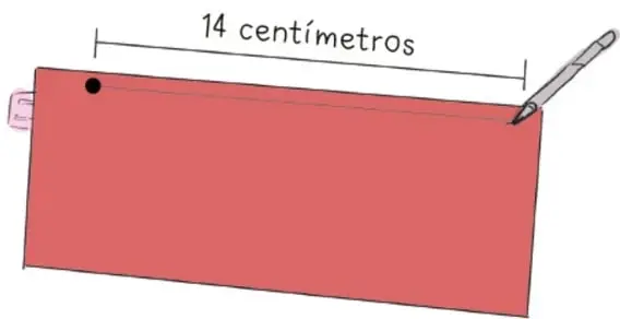 Envase de cartón rojo con una marca a 14 centímetros desde la base, señalada con una regla y plumón.