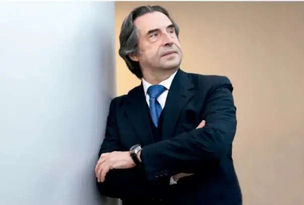 Fotografía de un hombre adulto con traje y corbata azul, con brazos cruzados, apoyado en una pared; probablemente un especialista o autor relacionado con el tema.