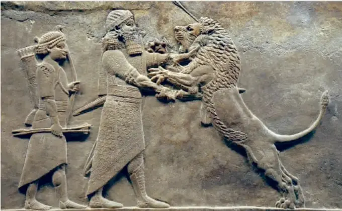 Bajorrelieve asirio que muestra a un rey cazando un león, acompañado por un sirviente.