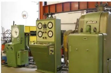 Fotografía de maquinaria industrial verde de gran tamaño dentro de una nave, ilustrando aplicaciones de los materiales en la industria.