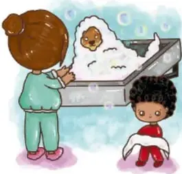 Niños bañando a un perro blanco en una tina con burbujas.