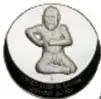 Medalla circular plateada vista por el reverso, que muestra una figura humana (Luchador Olmeca) al centro.