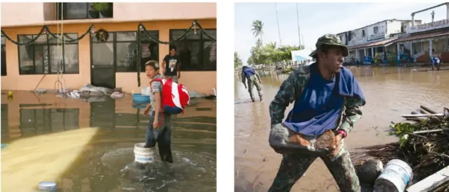 Joven con uniforme de protección civil cargando escombros en una calle inundada con basura.