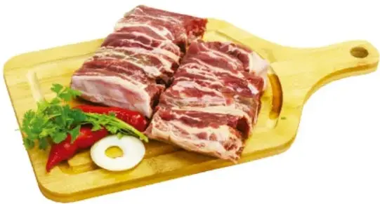 Tabla de madera con carne cruda, chile, cebolla y perejil.